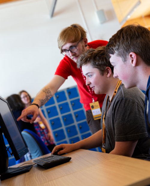 Male teacher and male students at a computer